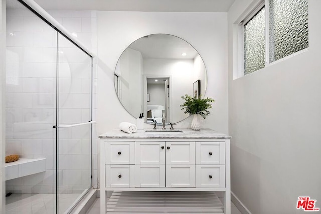 bathroom featuring vanity and a shower with door