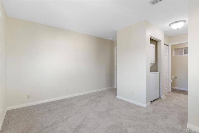 unfurnished room with stacked washer / dryer and light colored carpet