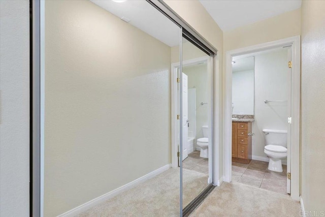 bathroom featuring tile patterned floors, vanity, toilet, and a shower