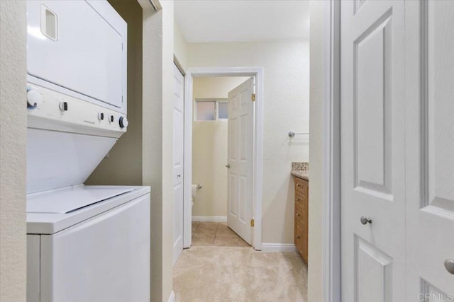 washroom featuring stacked washer and dryer and light colored carpet