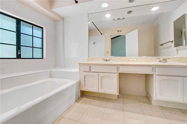 bathroom with tile patterned floors, vanity, and a tub to relax in