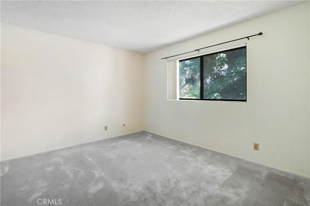 carpeted empty room featuring a textured ceiling