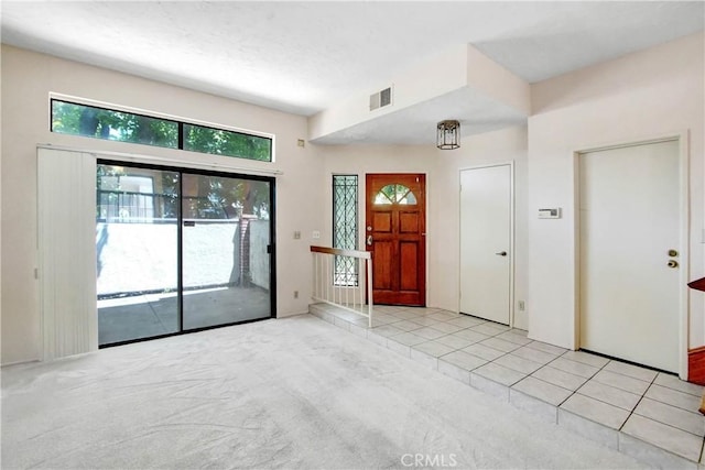 foyer featuring light carpet