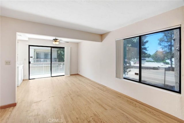 empty room with ceiling fan and light hardwood / wood-style floors