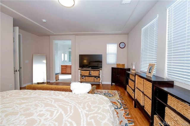 bedroom with light hardwood / wood-style flooring and ensuite bath