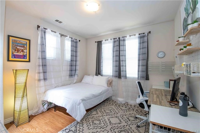 bedroom featuring hardwood / wood-style floors and multiple windows