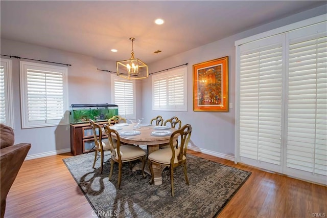 dining space with a notable chandelier, light hardwood / wood-style flooring, and plenty of natural light