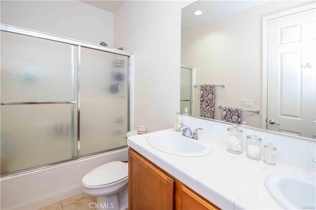 full bathroom with toilet, tile patterned floors, bath / shower combo with glass door, and vanity