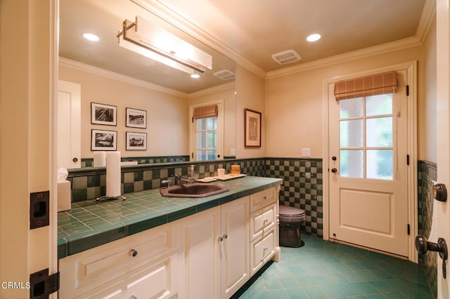 bathroom featuring tile walls, ornamental molding, vanity, and toilet