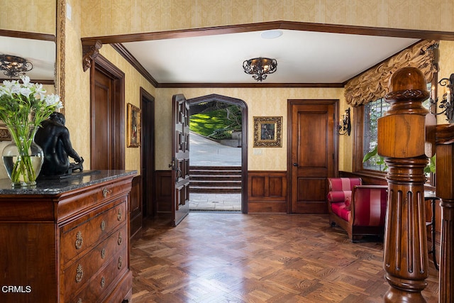 foyer entrance featuring dark parquet flooring, crown molding, and vaulted ceiling