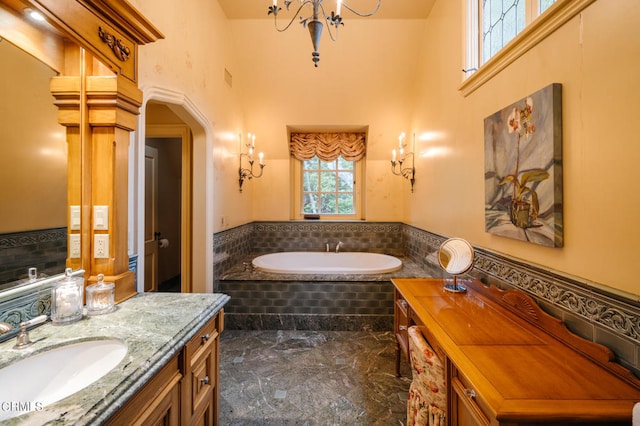 bathroom with vanity, tiled bath, and a high ceiling