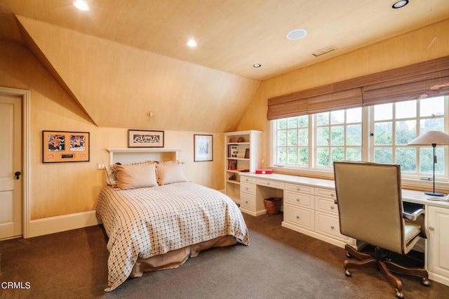 carpeted bedroom featuring lofted ceiling, wooden walls, and built in desk