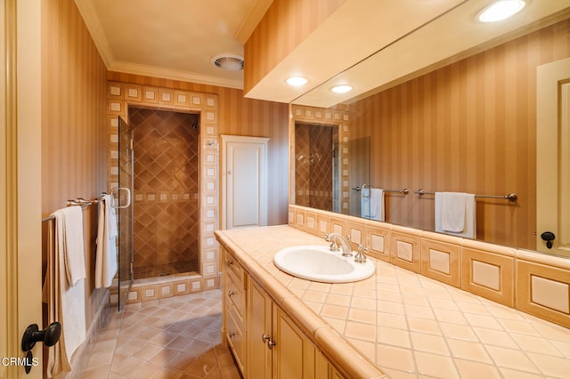 bathroom with ornamental molding, tile patterned floors, walk in shower, and vanity