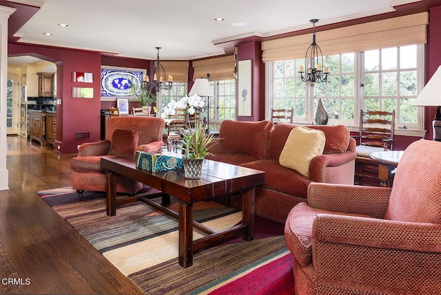 living room with dark wood-type flooring, plenty of natural light, and a chandelier