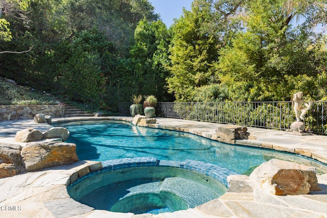 view of pool featuring an in ground hot tub