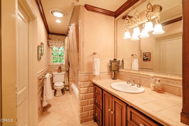 bathroom with vanity, tile walls, crown molding, and toilet