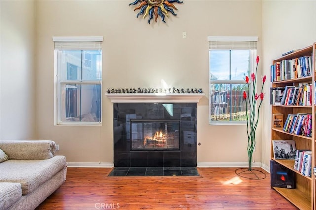 living room featuring a tile fireplace, hardwood / wood-style floors, and a wealth of natural light