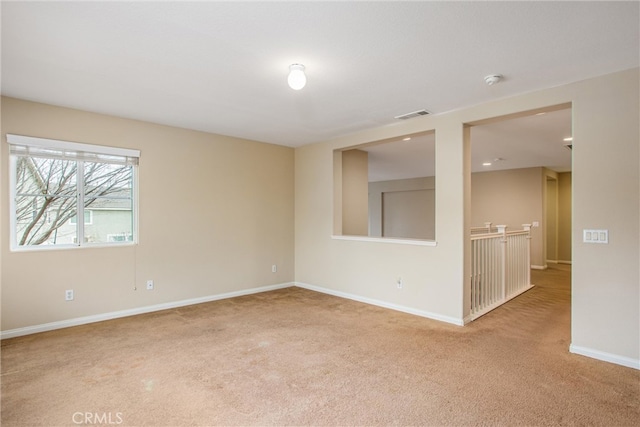 carpeted spare room featuring visible vents and baseboards