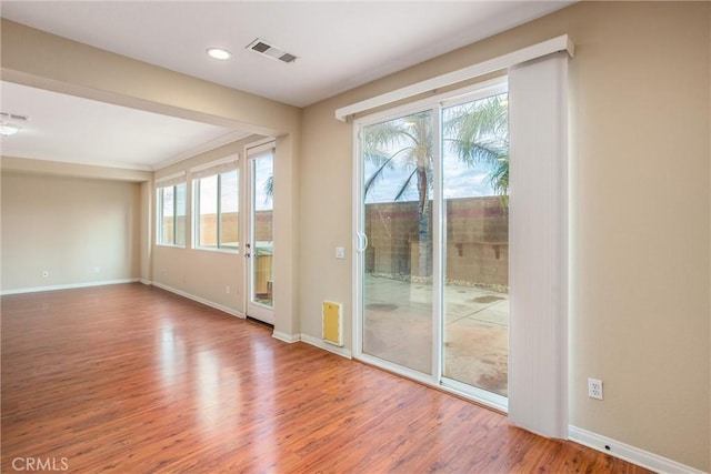 spare room with visible vents, recessed lighting, baseboards, and wood finished floors