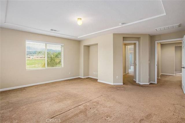 carpeted spare room featuring visible vents and baseboards