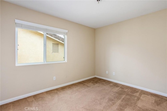 carpeted empty room with baseboards