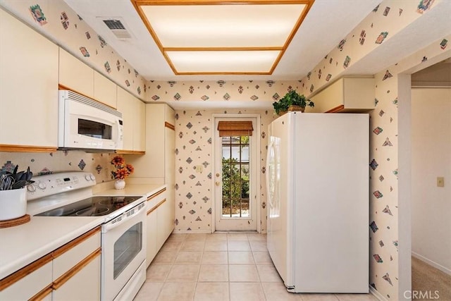 kitchen featuring light tile patterned flooring and white appliances