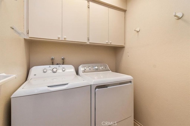 laundry room featuring cabinets and washer and dryer