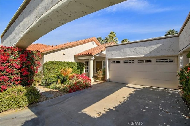 128 Desert Falls Dr E, Palm Desert, CA 92211 - view of front of home with an attached garage, stucco siding, driveway, and a tile roof