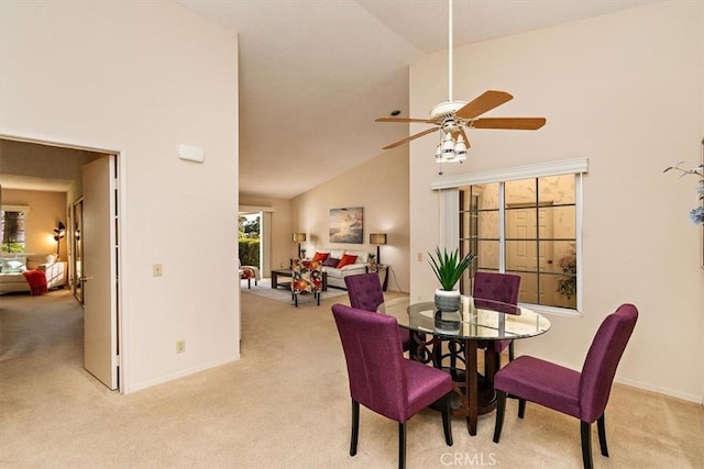 dining space featuring light carpet, high vaulted ceiling, and ceiling fan