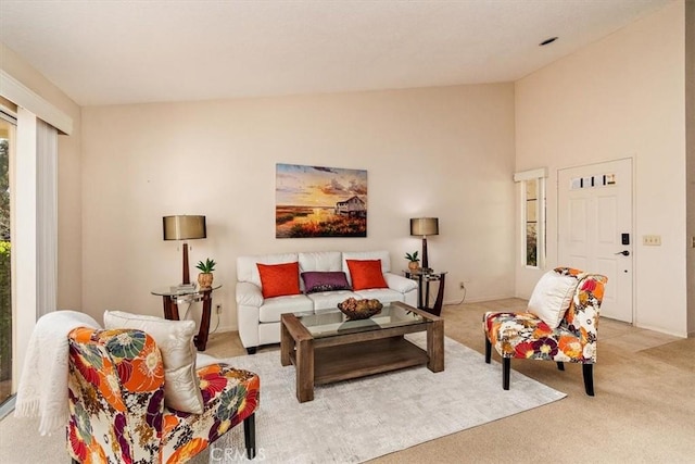 carpeted living room featuring high vaulted ceiling