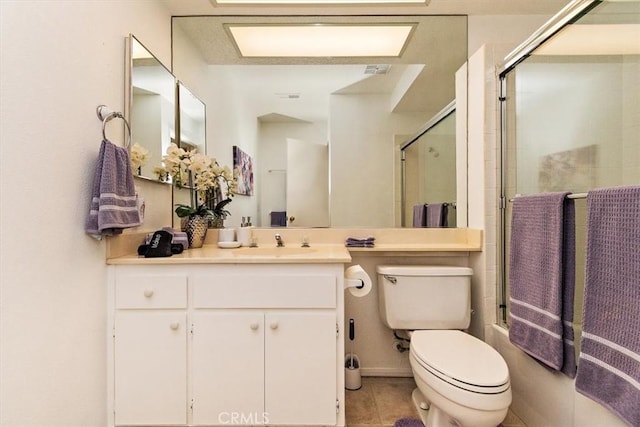 full bathroom featuring tile patterned floors, vanity, bath / shower combo with glass door, and toilet