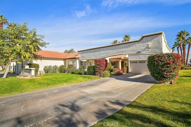 128 Desert Falls Dr E, Palm Desert, CA 92211 - view of front of house with a garage, concrete driveway, a front lawn, and stucco siding