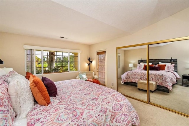 carpeted bedroom with a closet and lofted ceiling