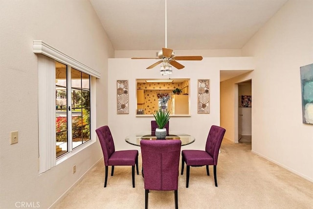 dining space featuring light colored carpet, vaulted ceiling, and ceiling fan