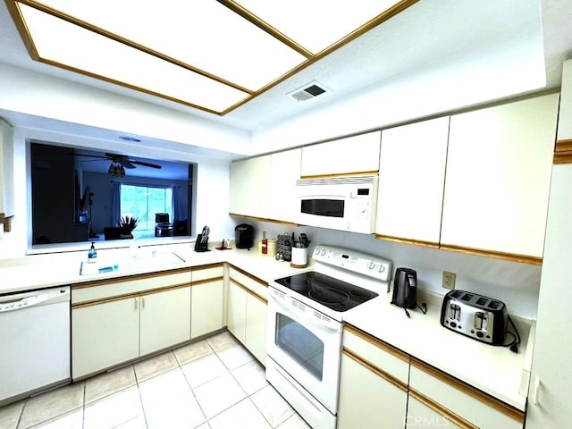 128 Desert Falls Dr E, Palm Desert, CA 92211 - kitchen featuring white appliances, a sink, light countertops, light tile patterned floors, and white cabinetry