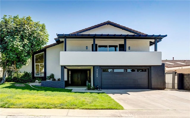 view of front facade with a balcony, a front lawn, and a garage