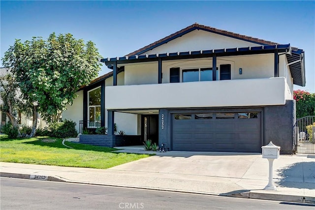 view of front of property with a garage, a balcony, and a front lawn