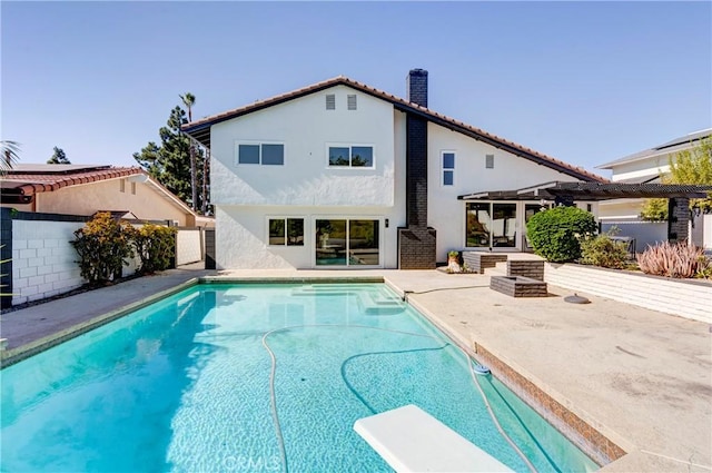 view of pool with a patio area and a diving board