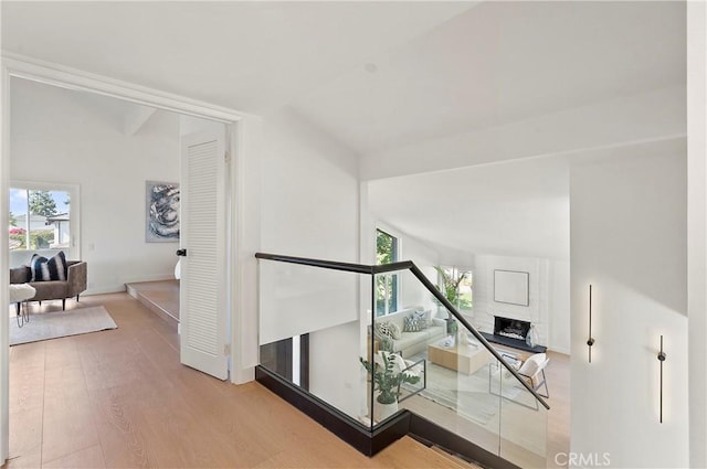 corridor featuring light hardwood / wood-style floors and vaulted ceiling