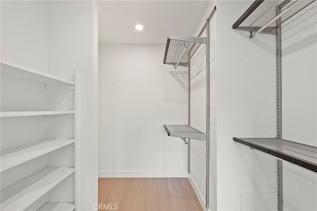 walk in closet featuring light hardwood / wood-style flooring