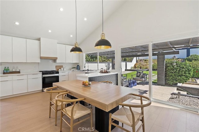 kitchen with range with gas stovetop, light hardwood / wood-style floors, white cabinetry, and sink