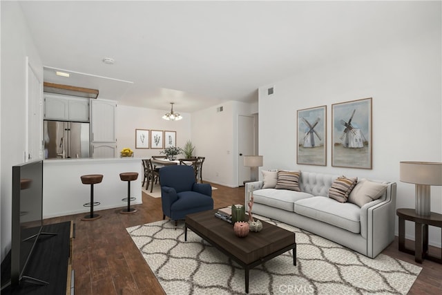 living room with a notable chandelier and dark hardwood / wood-style flooring