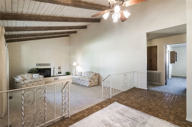 unfurnished living room featuring ceiling fan, a fireplace, lofted ceiling with beams, wood ceiling, and dark colored carpet