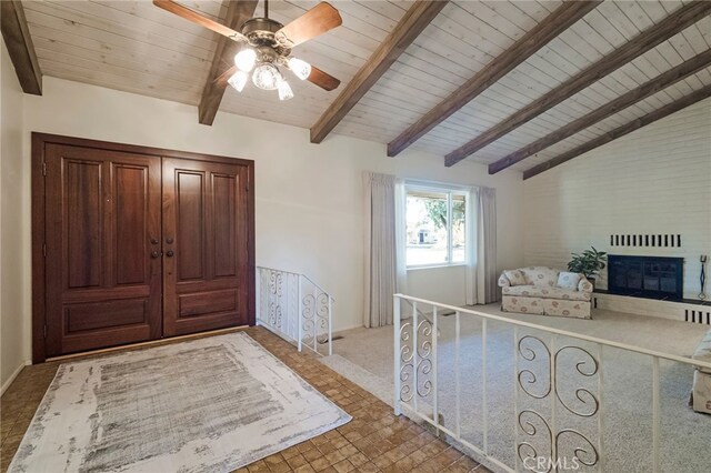 unfurnished bedroom with ceiling fan, lofted ceiling with beams, and wooden ceiling