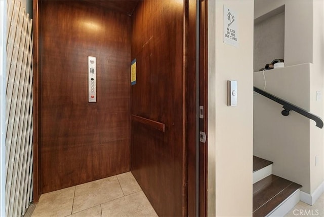 hall with light tile patterned flooring and elevator