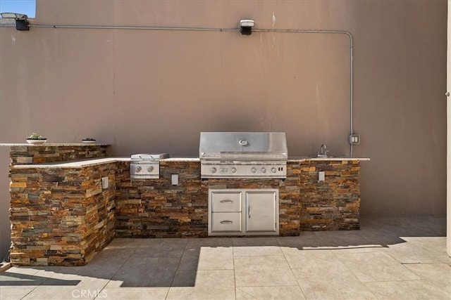 view of patio featuring an outdoor kitchen, sink, and area for grilling