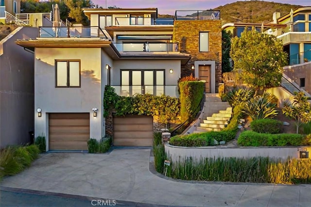 contemporary house with a garage and a balcony