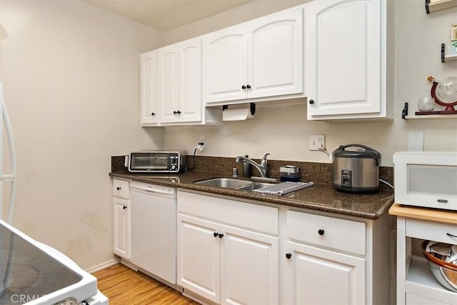 kitchen featuring white cabinetry, white appliances, sink, and dark stone counters