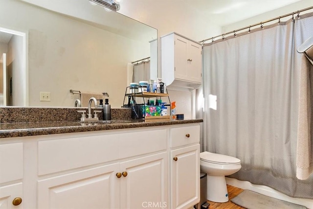 full bathroom featuring hardwood / wood-style flooring, toilet, shower / bath combo, and vanity