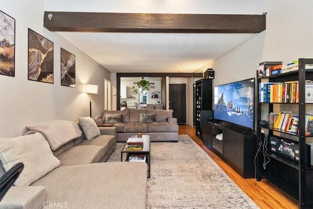 living room featuring beamed ceiling and wood-type flooring